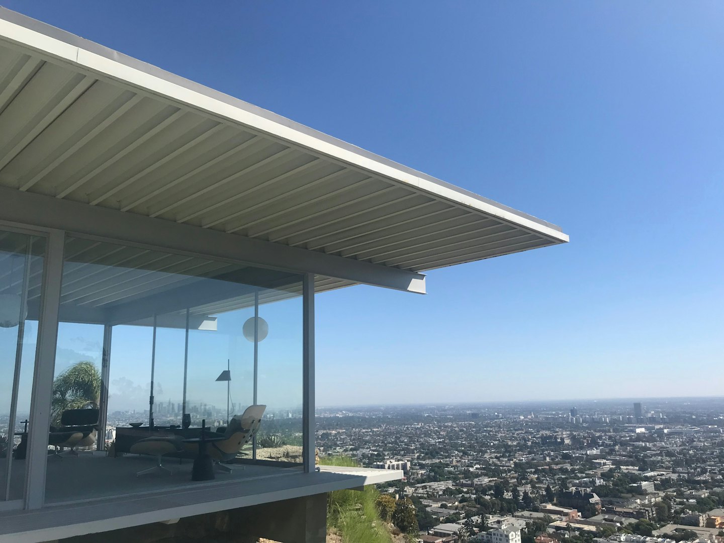 Moderna casa di vetro con tetto a sbalzo si affaccia sullo skyline della città.