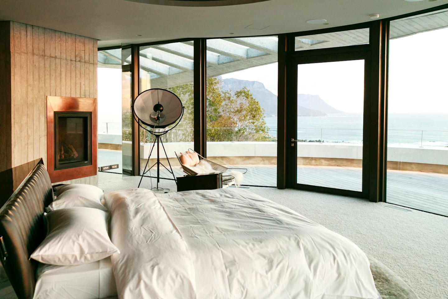 Camera da letto moderna con vista sull'oceano e camino.